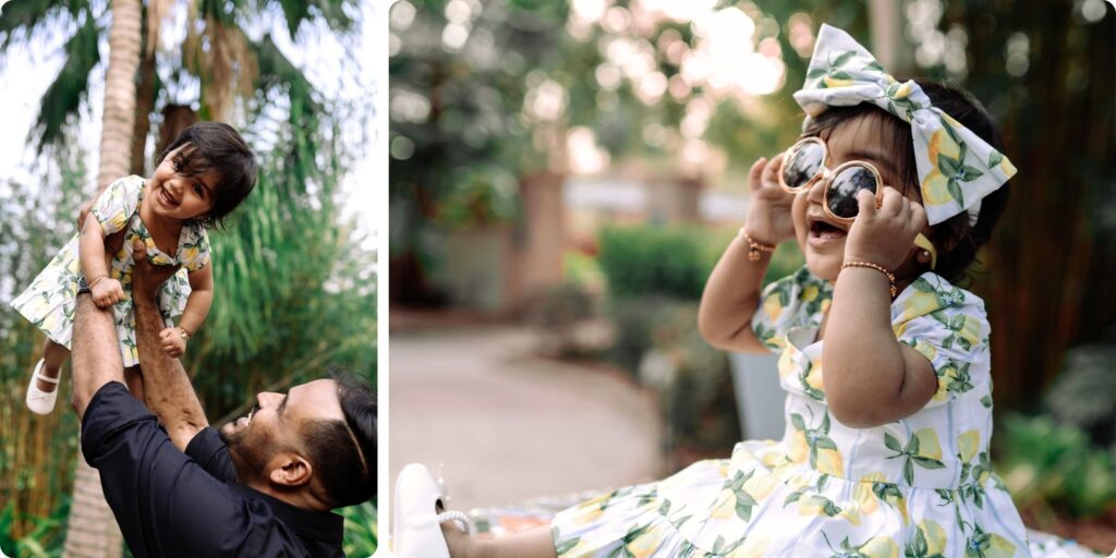 A joyful toddler in a lemon-print dress plays during her first birthday photography session in St. Pete—smiling as her dad lifts her in the air and trying on sunglasses with big, happy expressions, capturing memories full of sunshine and personality.