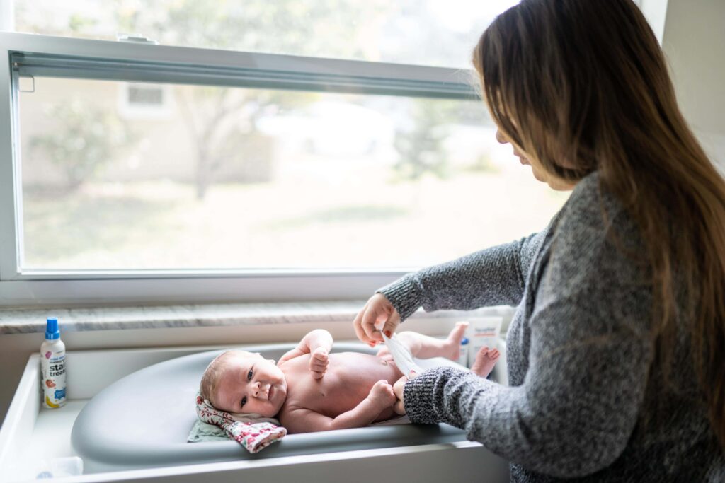 Mom changes her baby on the changing table in the nursery