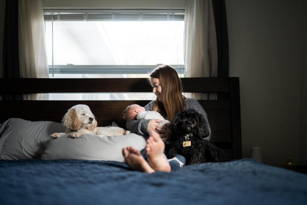 A mom snuggles her daughter and pups