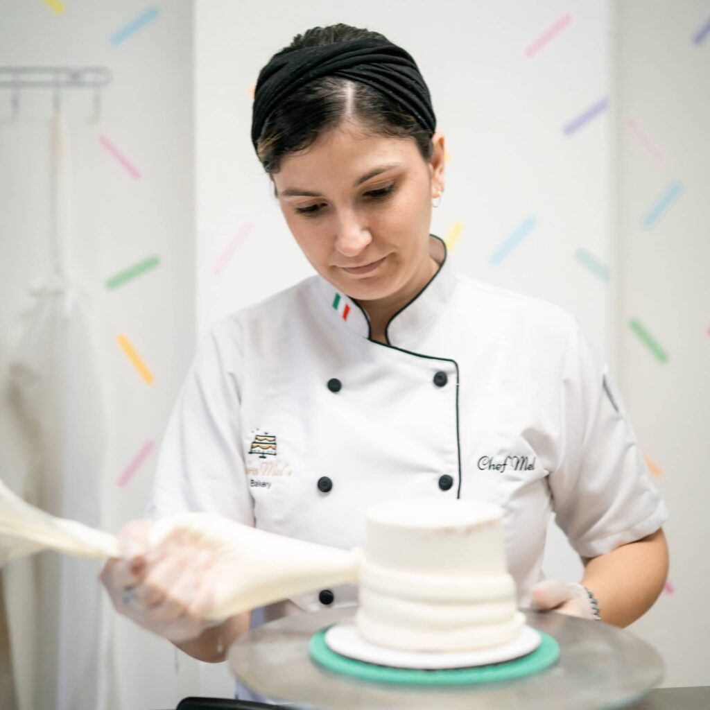 Chef Mel of CaraMel's Bakery decorates a wedding cake