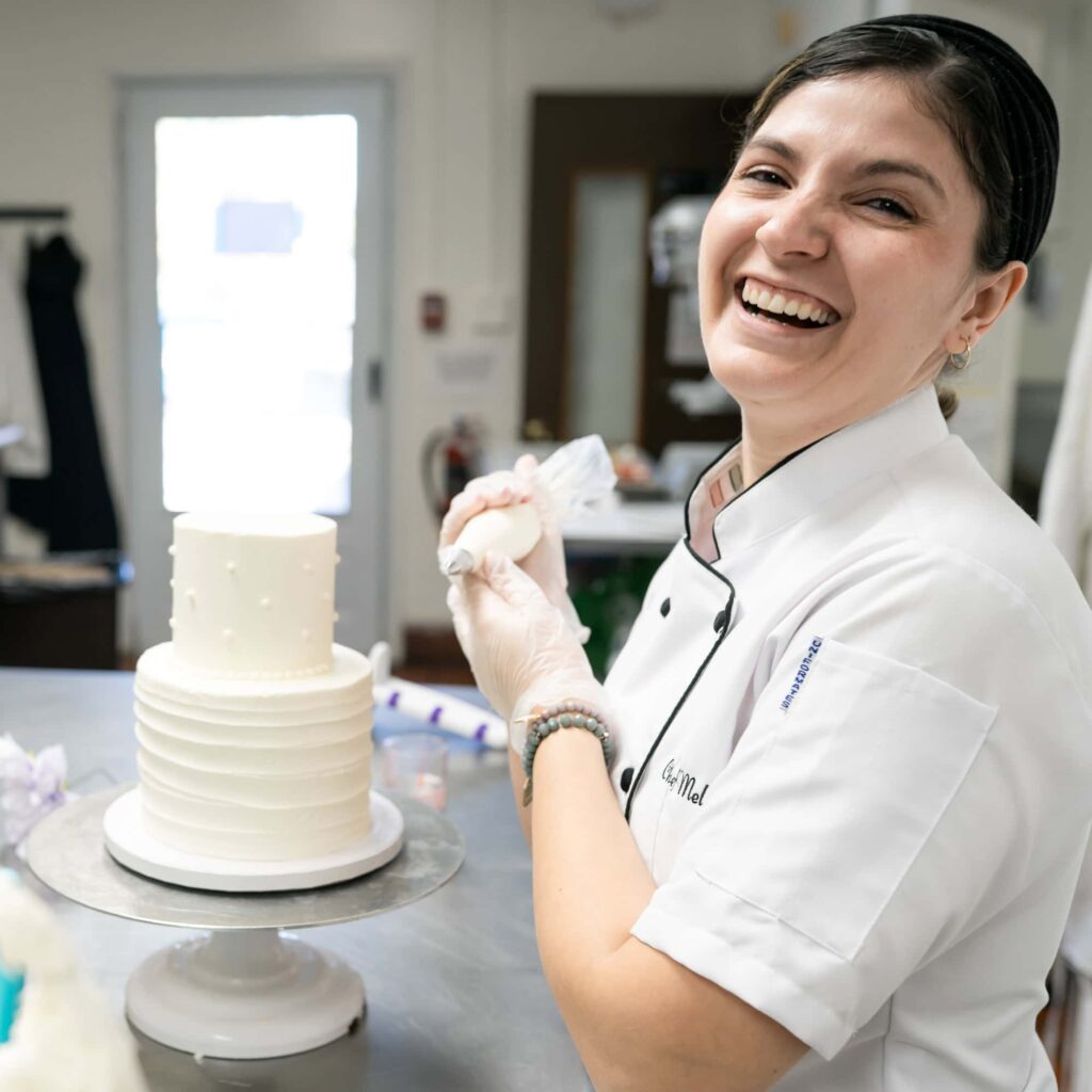 Chef Mel decorates a wedding cake