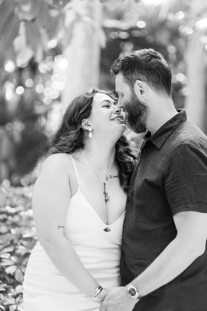 Couple smiling and leaning in close during their Sunken Gardens family photography session in St. Petersburg