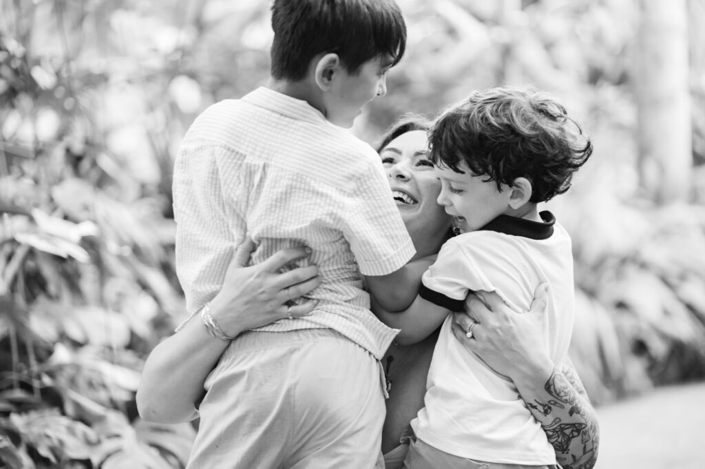 Mother hugging two of her sons during their relaxed family session at Sunken Gardens in St. Petersburg