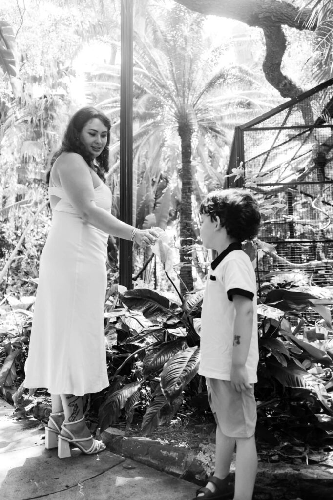 Mother and young son walking hand in hand near the tropical plants at Sunken Gardens in St. Petersburg