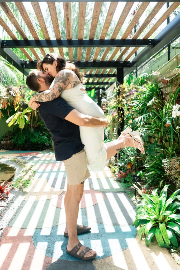 Couple sharing a romantic kiss while he lifts her during Sunken Gardens family photographs in St. Petersburg