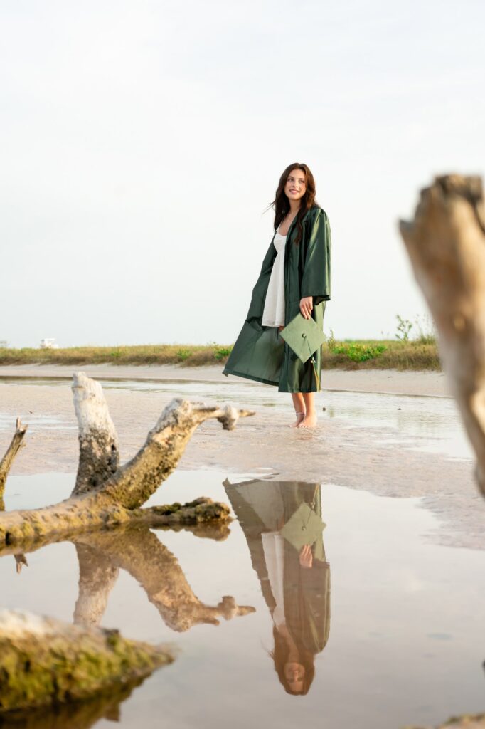 Graduation portrait with reflection in water at Fort De Soto North Beach