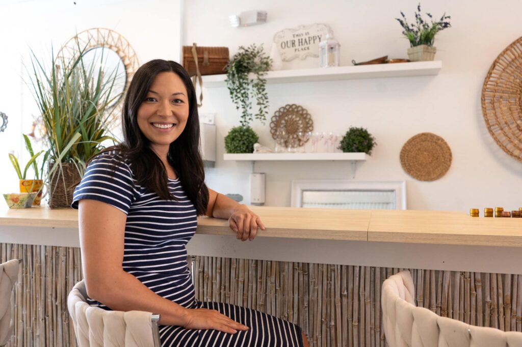 Audra of Til Death Weddings & Design sits at a bright café counter with natural textures and plants, captured by Erin Vestal Photography in Tampa, Florida.
