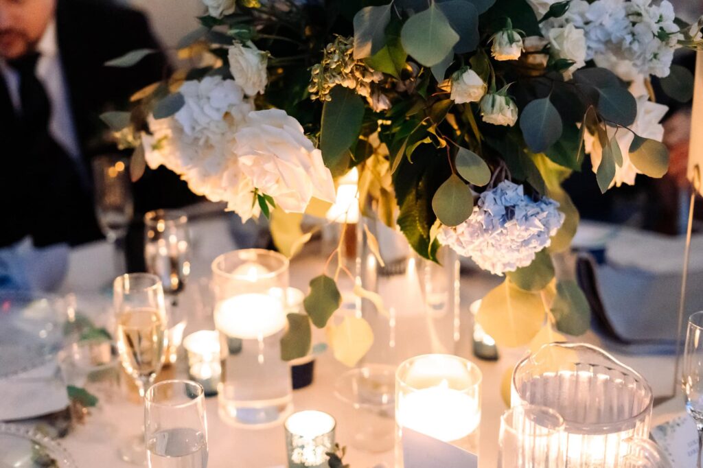 Elegant candlelit wedding table centerpiece with white roses and blue hydrangeas, photographed by Erin Vestal in St. Petersburg, Florida.
