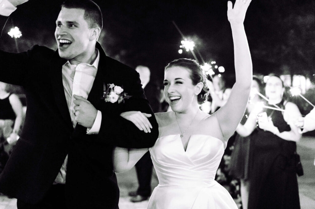 Bride and groom laughing as they exit their reception with sparklers, captured by St. Pete wedding photographer Erin Vestal.