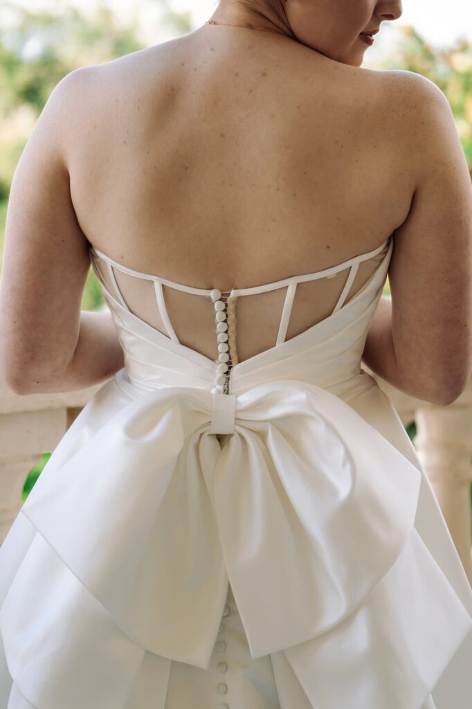 Close-up of wedding dress bow detail and satin buttons on back of gown, captured by St. Petersburg wedding photographer Erin Vestal.