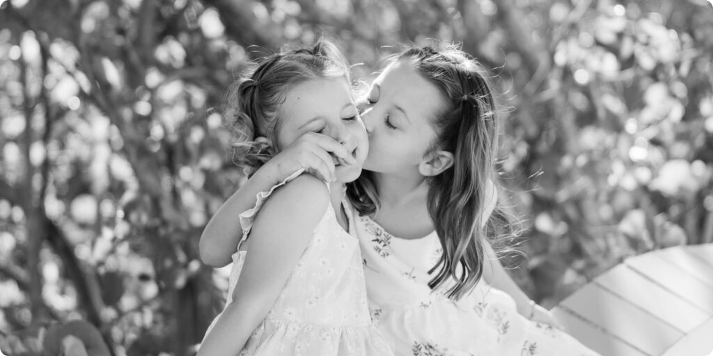 Two sisters sharing a sweet moment together during a family photo session in St. Pete