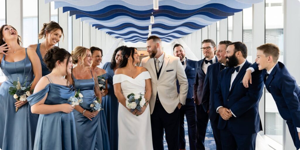 Full wedding party laughing together on the Opal Sands sky bridge at Clearwater Beach wedding venue