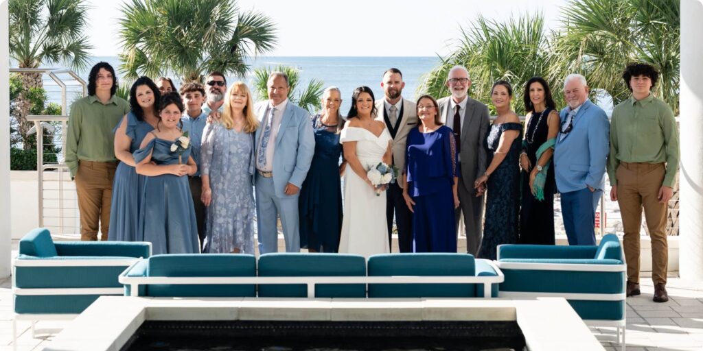 Extended family wedding portrait at Opal Sands Resort Clearwater Beach with palm trees and Gulf of Mexico in background