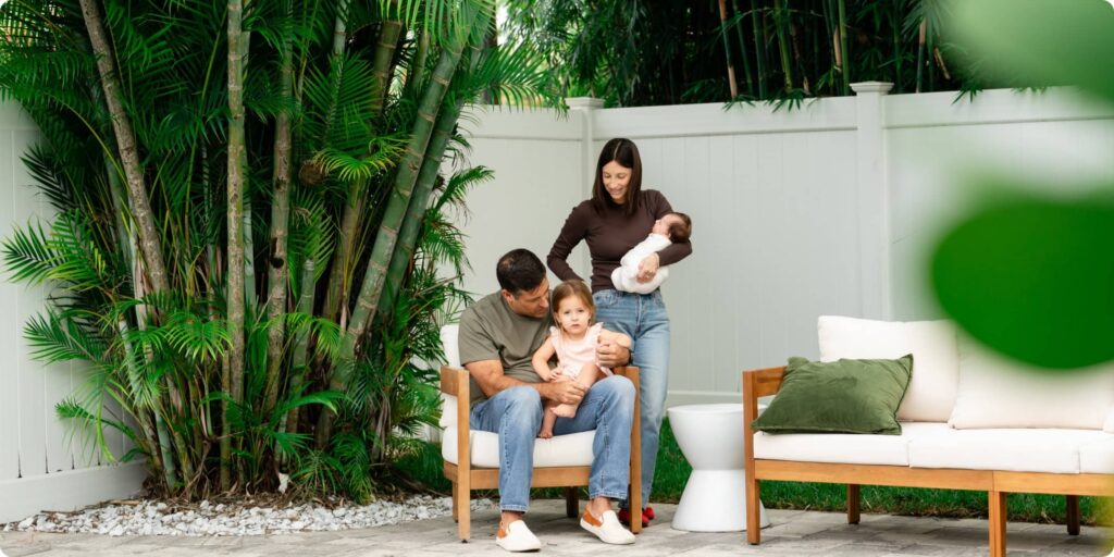 St. Petersburg family of four with toddler and newborn in their Crescent Heights backyard surrounded by tropical greenery