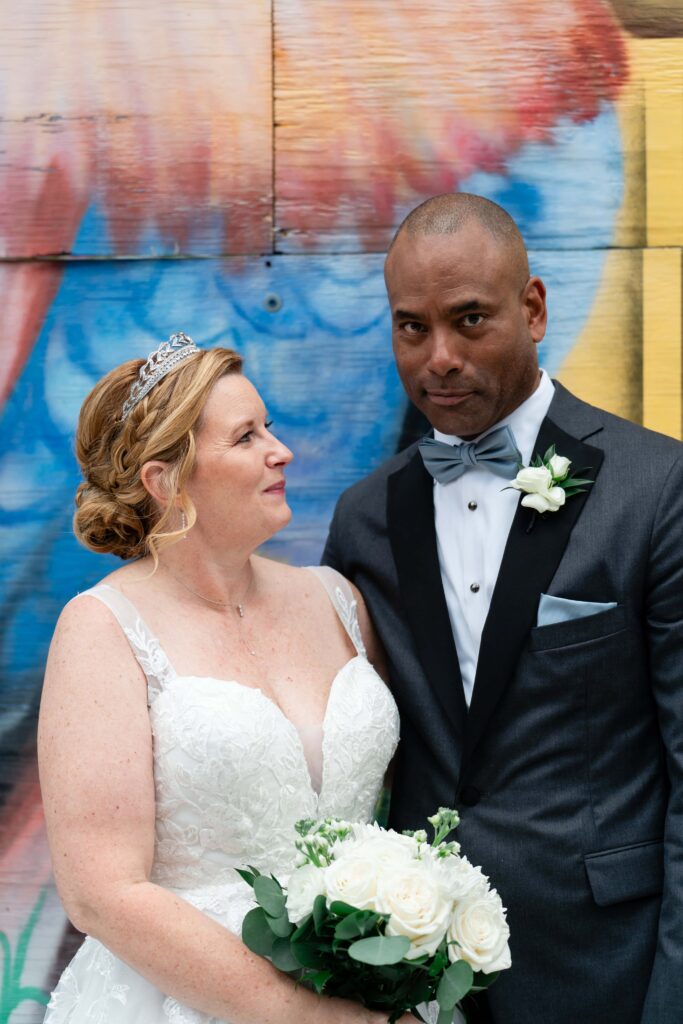 Bride and Groom stand in front of the mural in Ybor City, Tampa, Florida